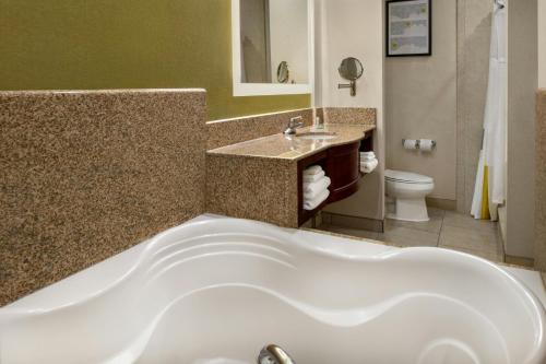 a bathroom with a tub and a sink and a toilet at City Express By Marriott Rancho Cucamonga in Rancho Cucamonga