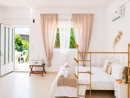 a white bedroom with a bed and a window at Studio Malades, Heraklion in Maládhes
