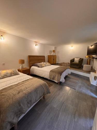 a bedroom with two beds and a chair at les chambres d'hotes du chalet in Venaco