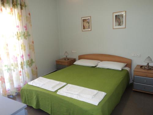 レフカダにあるVioleta Apartmentsのベッドルーム1室(緑色のベッド1台、2泊用スタンド付)