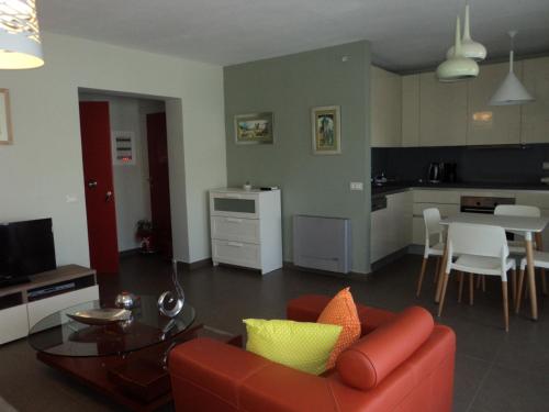レフカダにあるVioleta Apartmentsのリビングルーム(赤いソファ、テーブル付)
