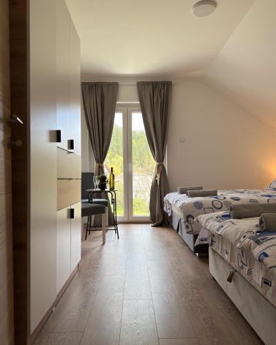 a bedroom with two beds and a desk and a window at Apartmani Tara House in Milekići