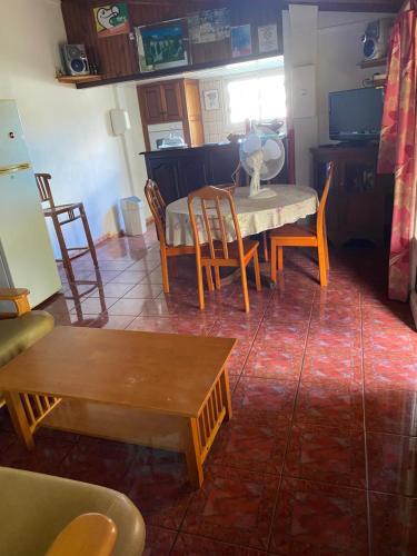a living room with a table and chairs at pti caze Hoarau in Le Tampon