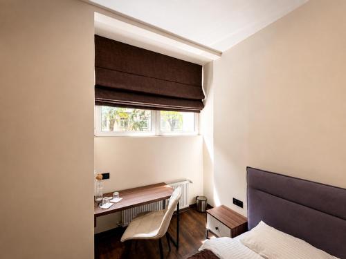 a bedroom with a bed and a desk and a window at Prime Hotel in Dnipro