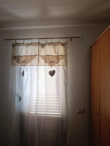 a window with a curtain with faces on it at ALMA'RE Le Trame di KaSa Experience in Porto Ottiolu