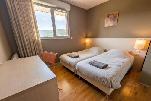 two beds in a small room with a window at Bright two bedroom duplex apartment in Divonne-les-Bains