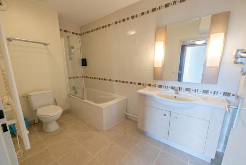 a bathroom with a sink and a tub and a toilet at Bright two bedroom duplex apartment in Divonne-les-Bains