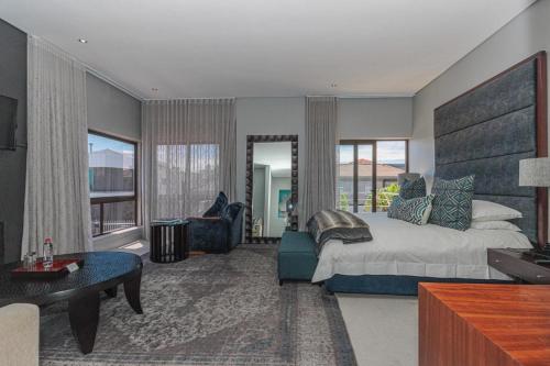 a bedroom with a large bed and a living room at Atlantic Waves Guest House in Cape Town