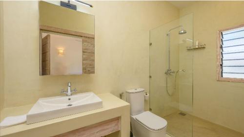 a bathroom with a sink and a toilet and a shower at Dhahabu Village - Villa 244 Beachfront stay in Mambrui