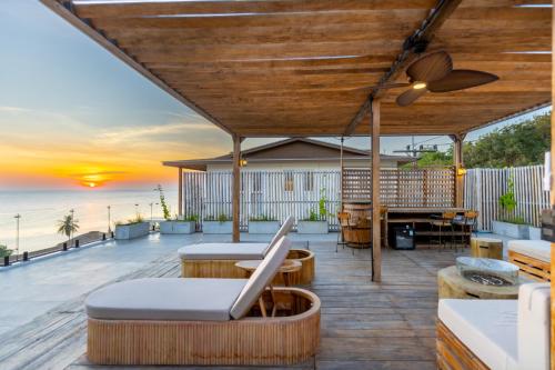 an outdoor deck with tables and chairs and the ocean at Villa Kinnari in Ko Phangan