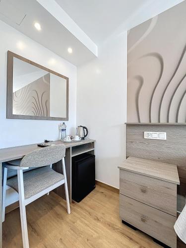 a room with a desk and a mirror and a table at Hotel Noguera El Albir in Albir