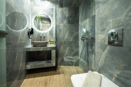 a bathroom with a sink and a shower with a mirror at Moon Boutique Hotel - Ultra Luxury Suites with Pool, Perfect for Fun and Relaxation By Villa Mana Gers in Laganas