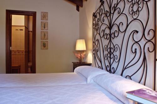 a bedroom with a white bed with a metal headboard at Posada Real El Sendero del Agua in Trefacio