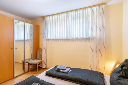 a bedroom with a bed and a window and a chair at Ferienhaus Gut Düneburg in Haren