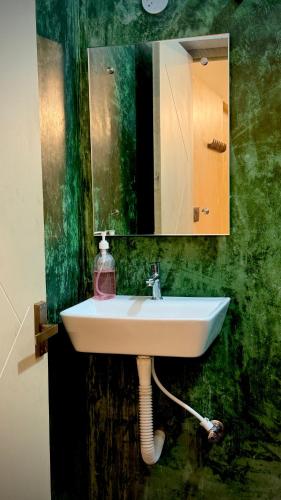 a bathroom with a sink and a mirror at Serenity Beach Inn in Pondicherry