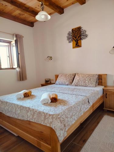 a bedroom with a large bed with two teddy bears on it at Small Stone Cottage in Virpazar