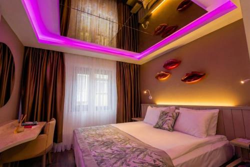 a bedroom with a bed with a purple lighting at Hotel 2000 Kavaklıdere in Ankara