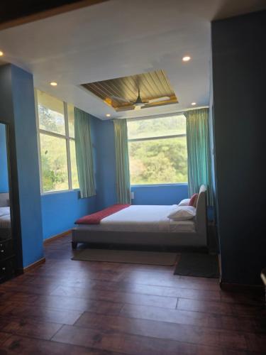 a bedroom with a bed in a room with blue walls at SPKA Jungle Resort in Vālpārai