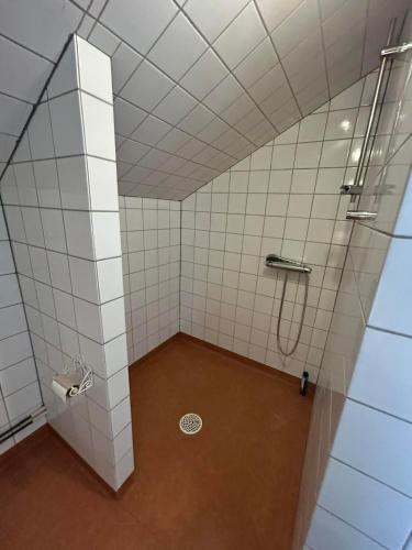 a bathroom with a shower with white tiled walls at Halek Hem - Haga Nest in Haga
