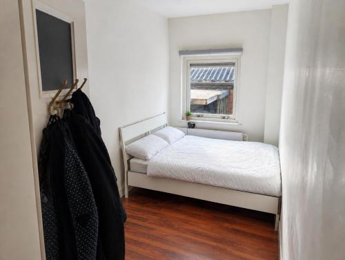 a small bedroom with a bed and a window at Appartement Bongerdstraat in Nijmegen