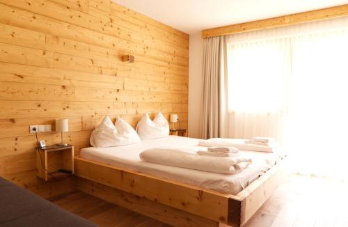 a bedroom with a bed with a wooden wall at Alpenchalet im Leutaschtal in Leutasch