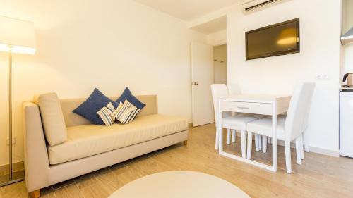 a living room with a couch and a table at Globales Janeiro in Can Picafort