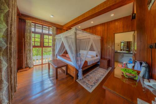 a bedroom with a bed with a mosquito net at Hotel Levon Ella in Ella