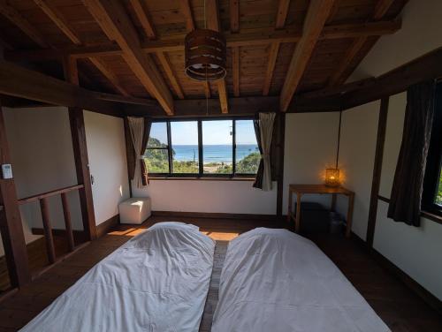 a bedroom with a bed and a large window at koco in Nishinoomote