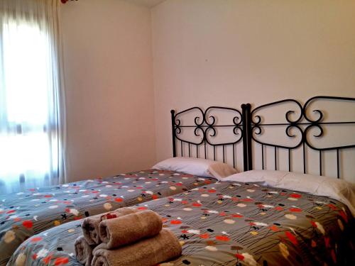 1 dormitorio con 1 cama con 2 toallas en Apartamentos Tuara, en El Run
