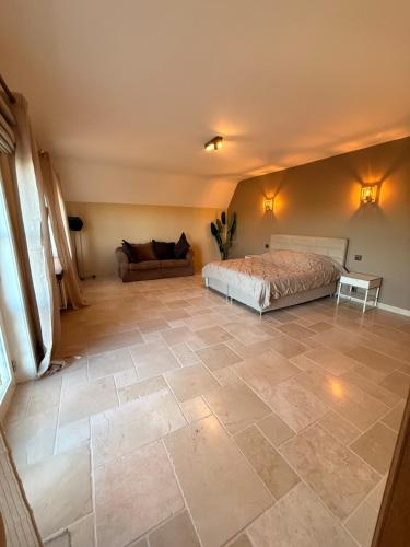 a bedroom with a bed and a couch at Château D - Roncheval in Mouscron