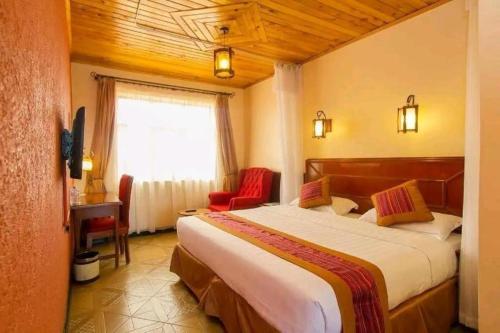 a hotel room with a large bed and a window at Seasons Airport Hotel Nairobi in Nairobi