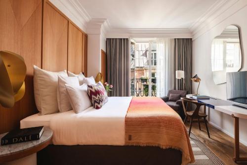 a hotel room with a bed and a desk at Hôtel Vernet Champs Elysées Paris in Paris