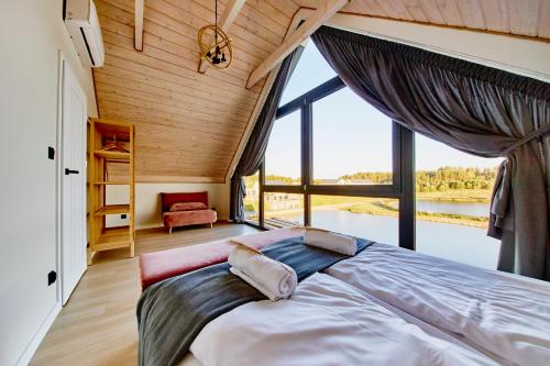 a large bed in a room with a large window at Biała Woda in Suwałki
