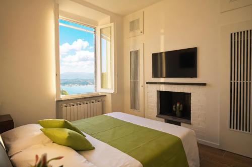 a bedroom with a bed with a fireplace and a television at Il Collina - Poets'Vista in La Spezia