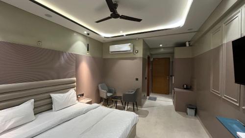a bedroom with a bed and a ceiling fan at Us Group Stays Omaxe Hazratganj in Nalmatha