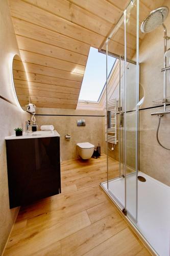 a bathroom with a shower and a sink and a toilet at Biała Woda in Suwałki