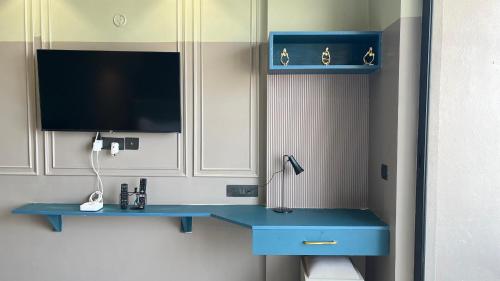 a room with a blue desk and a tv at Us Group Stays Omaxe Hazratganj in Nalmatha