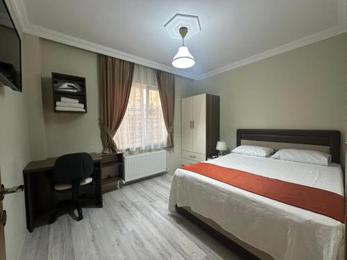 a bedroom with a bed and a desk and a window at Borahan Hotel in Trabzon