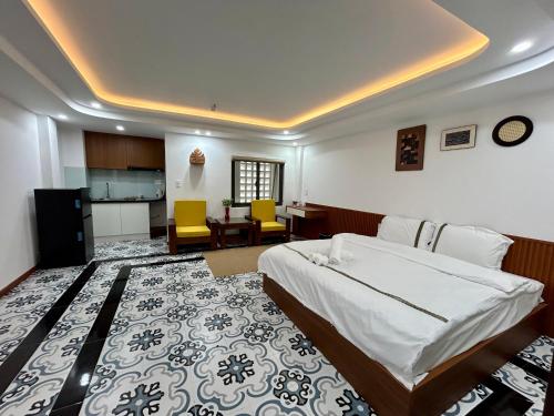a bedroom with a large bed and a kitchen at Han House's Apartment in Danang