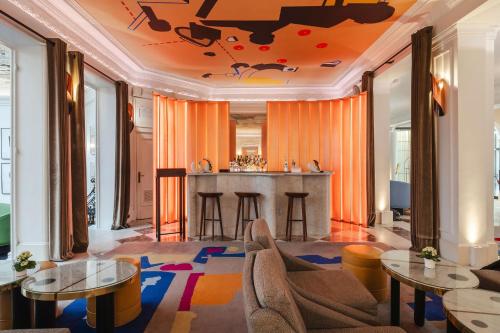 a living room with a bar with orange curtains at Hôtel Vernet Champs Elysées Paris in Paris