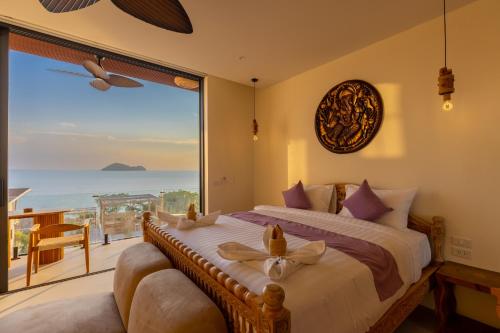 a bedroom with a large bed and a large window at Villa Gaia in Ko Phangan