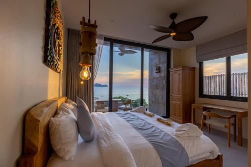 a bedroom with a bed with a view of the ocean at Villa Gaia in Ko Phangan