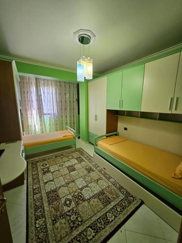 an empty room with two beds and a rug at SunBeach Apartament in Golem