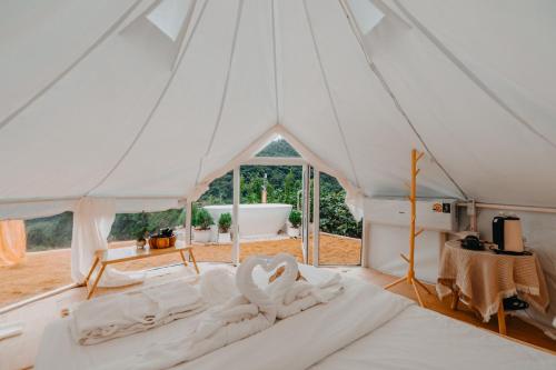 two white swans sitting on a bed in a marquee at เดอะเฌอร์ โฮมสเตย์-The Sher in Ban Thung Phan Ha