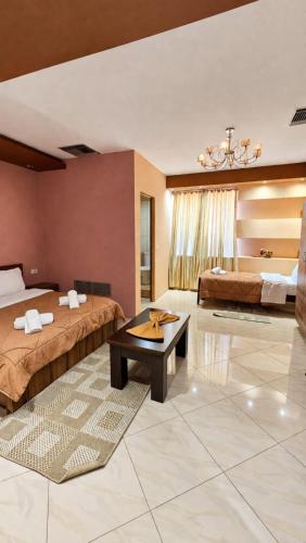 a hotel room with two beds and a table at Hotel Alysa Korce in Korçë