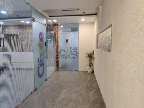 an office hallway with a door and a potted plant at FlxHo Corporate Stays - Udyog Vihar in Gurgaon