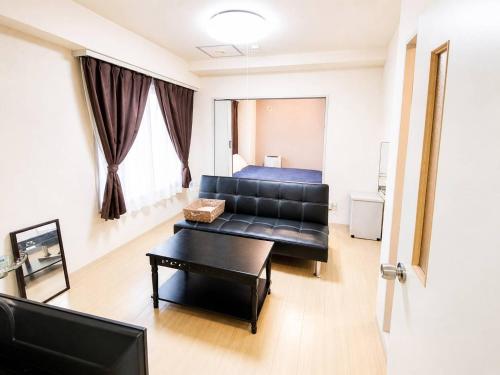 a living room with a couch and a table at E-Horizon北2条ビル in Sapporo