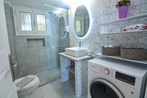 a bathroom with a washing machine and a sink at Aelia Luxury Suites Melissi in Xylokastro