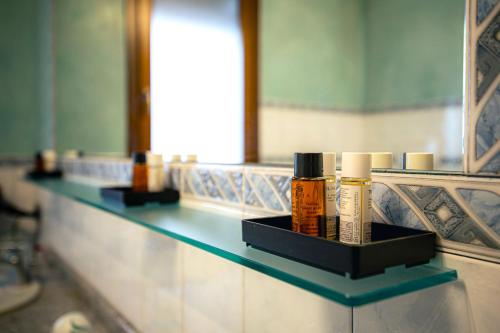 a shelf with bottles ofodorizers on a bathroom counter at Agri Alloggio Poggiolina in Bagnara di Romagna