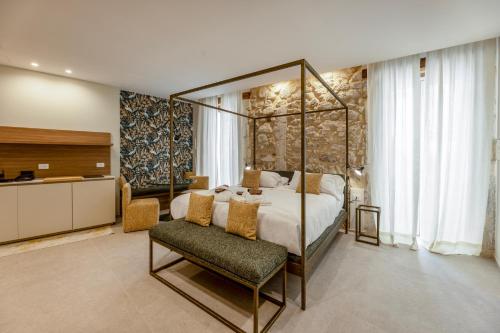 a bedroom with a bed and a chair in a room at Rial Collection Luxury Suite in Syracuse